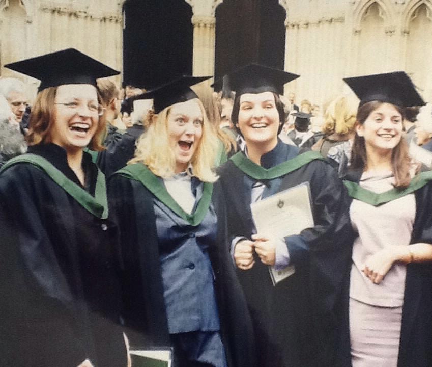 4 people standing outside of York Minster in graduation caps and gowns. The second to the right is Laura.