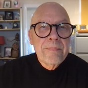 image of David Haley, a bald white man with black statement glasses