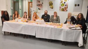 The students and their lecturer seated at the exhibition's banquet table