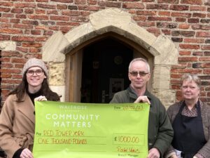 Red Tower volunteers holding a fundraising cheque