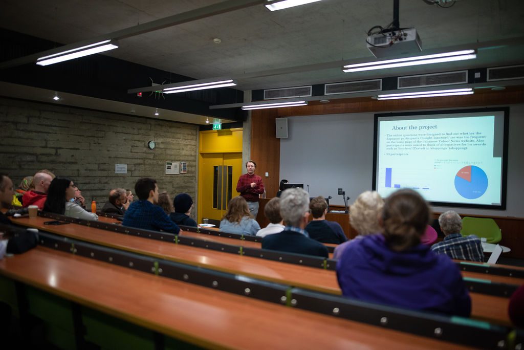 Image of Student stood at the front of a lecture hall presenting