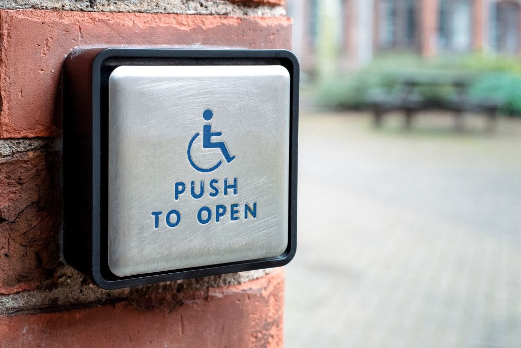 An accessible 'push to open button' on a brick wall on campus.