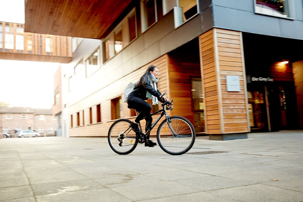 A student cycling through campus.