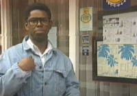 Image of Kevin Buckle. Kevin is a young Black man wearing a denim jacket and thick rimmed glasses.