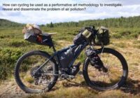 An image of Clare Nattress' bike in a rural terrain, it reads 'how can cycling be used as a performative art methodology to investigate and disseminate the problem of air pollution?'