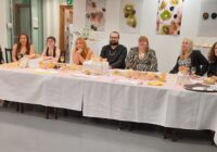 The students and their lecturer seated at the exhibition's banquet table