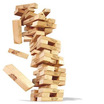 Image of Jenga - wooden blocks stacked but mid fall