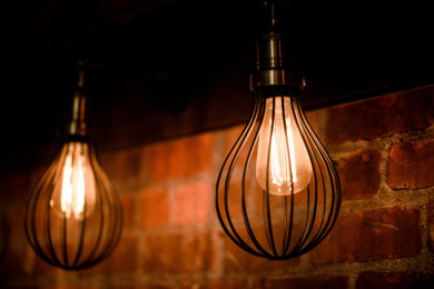 Image of lightbulbs against a brick wall.