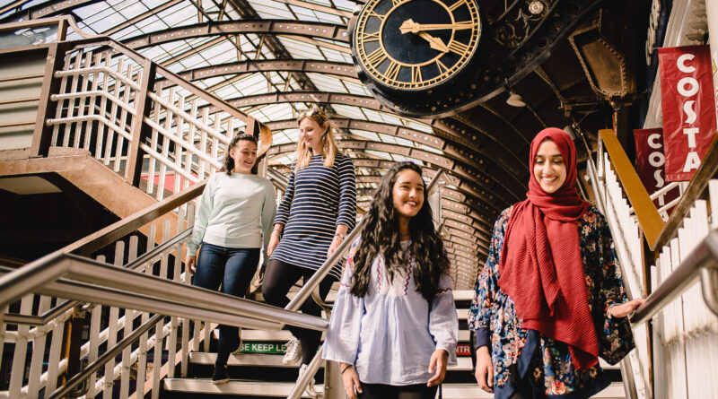 fours students walking down the stairs at the train station